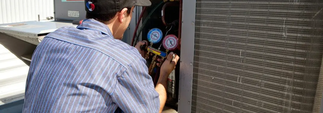HVAC technician servicing a condenser unit in Keizer