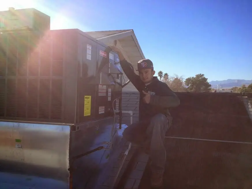 HVAC technician performing AC Tune-Up on a rooftop unit in Keizer